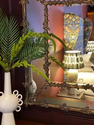 a mirror on a table with vases and a lamp at The Raeburn in Edinburgh