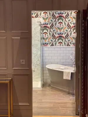 a bathroom with a bath tub and a tile wall at The Raeburn in Edinburgh