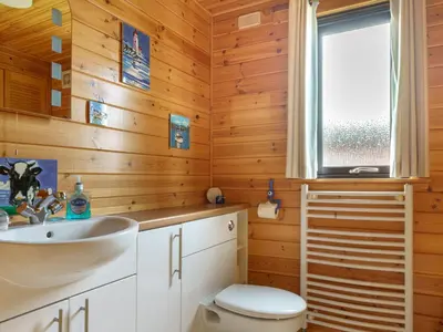 a bathroom with a sink and a toilet and a window at Chalet Lodge 9 by Interhome in Kinross