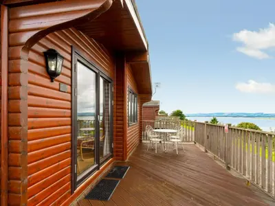 a wooden deck with a table and chairs on it at Chalet Lodge 9 by Interhome in Kinross