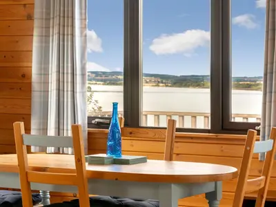 a table with two chairs and a vase on top at Chalet Lodge 9 by Interhome in Kinross