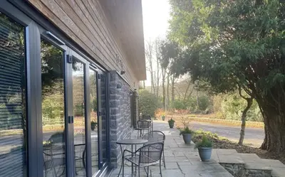 a patio with chairs and a table in front of a building at Garden Room Lodges in Alexandria