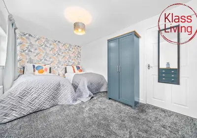 a bedroom with a bed and a blue door at West End House by Klass Living Bellshill in Bellshill