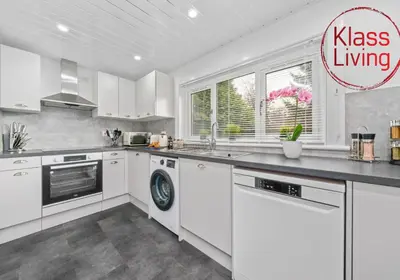 a kitchen with white cabinets and a dishwasher at West End House by Klass Living Bellshill in Bellshill