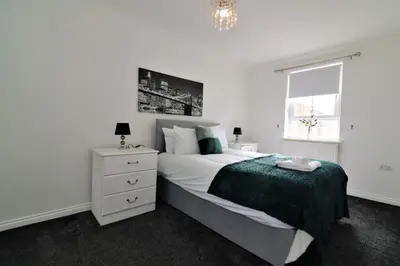 a white bedroom with a bed and a window at Signature - Kirkhill Middle in Kirkmuirhill