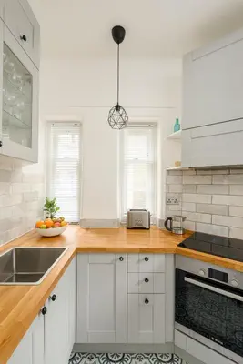 a kitchen with white cabinets and a wooden counter top at Heriot Bridge Hideaway by Calton Living in Edinburgh