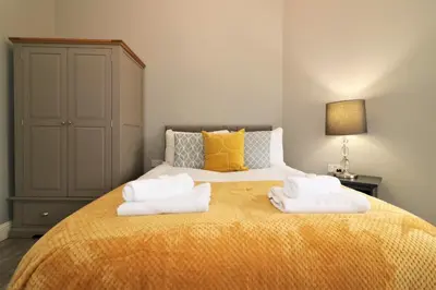 a bedroom with a bed with towels on it at Signature - Linden House Flat 4 in Airdrie