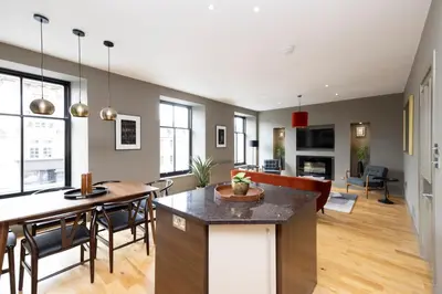 a kitchen and living room with a table and chairs at JOIVY Stylish Flat in New Town in Edinburgh