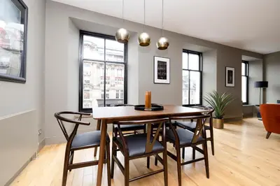 a dining room with a table and chairs at JOIVY Stylish Flat in New Town in Edinburgh