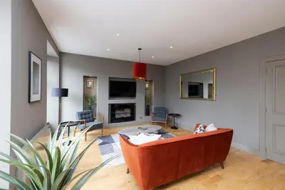 a living room with a couch and a fireplace at JOIVY Stylish Flat in New Town in Edinburgh