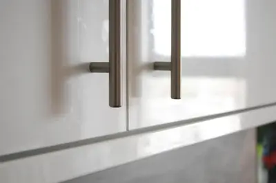 a kitchen with white cabinets with metal handles at Station Signature Apartment near Lanark in Carstairs