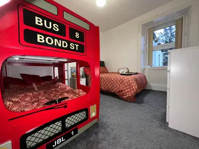 a red bus bed in a bedroom with a bed at Station Signature Apartment near Lanark in Carstairs