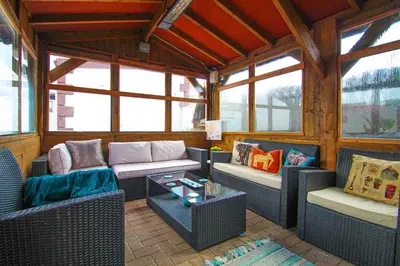 a screened in porch with couches and a table at Station Signature Apartment near Lanark in Carstairs