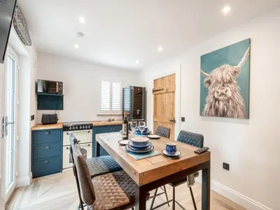 a kitchen with a wooden table and chairs at The Railway Sleeper in Hyndfordbridge-end
