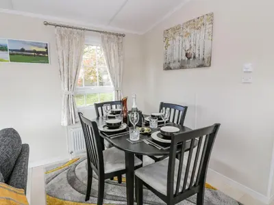 a dining room with a black table and chairs at 11 Mansion View in Helensburgh