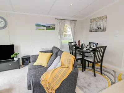 a living room with a gray couch and a table at 11 Mansion View in Helensburgh