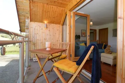 a tiny house with a table and a chair at Kennacraig Lodge in Whitehouse
