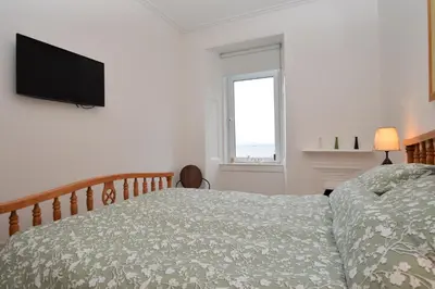 a bedroom with a bed and a flat screen tv at Glen Oirig in Hunters Quay