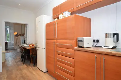 a kitchen with wooden cabinets and a table in a room at Glen Oirig in Hunters Quay