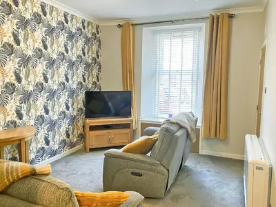 a living room with a chair and a television at The Wee Hideaway in Crieff