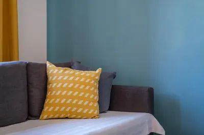 a couch with two yellow pillows on it at The Douglas - Spacious 2 bed apartment in Uddingston in Uddingston