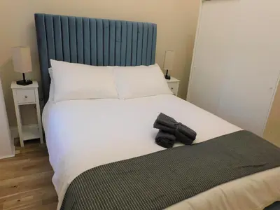 a bedroom with a large bed with a blue headboard at Beautiful 3 bed apt in the City Centre in Glasgow