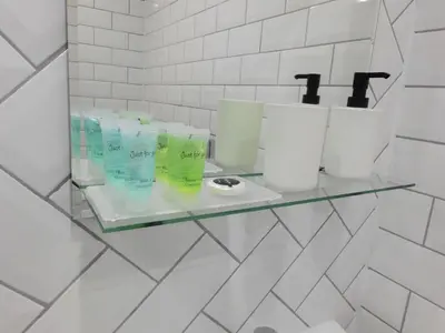a glass shelf in a bathroom with toilet paper at Beautiful 3 bed apt in the City Centre in Glasgow