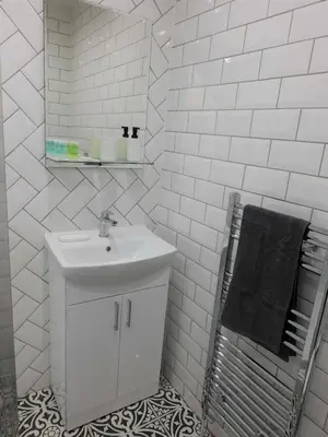 a white bathroom with a sink and a mirror at Beautiful 3 bed apt in the City Centre in Glasgow