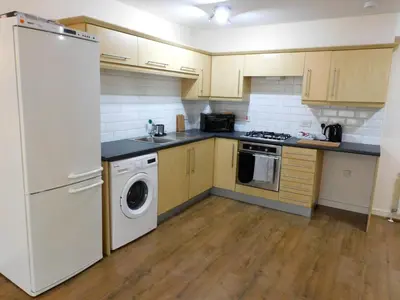 a kitchen with a white refrigerator and a dishwasher at Fabulous 2 bed apt 10 mins from City Centre in Glasgow