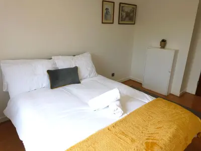 a white bed with two pillows on top of it at Charming 2 bed apt close to City and SEC Hydro in Glasgow
