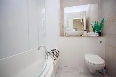 a white bathroom with a toilet and a sink at Bright Central Flat with Balcony and Free Parking in Glasgow