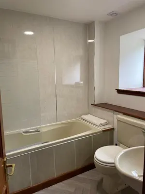 a bathroom with a tub and a toilet and a sink at Exclusive private estate cottage in Lochearnhead