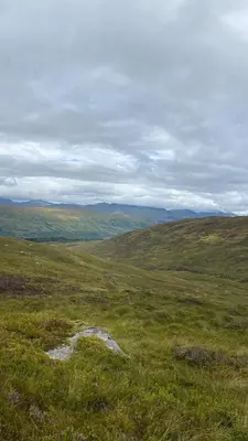 a field of grass with a puddle of water in it at Exclusive private estate cottage in Lochearnhead
