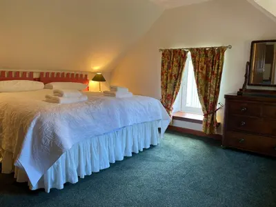 a bedroom with a bed and a dresser and a window at Exclusive private estate cottage in Lochearnhead