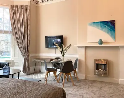 a living room with a table and a fireplace at The Buckingham Studio in Glasgow