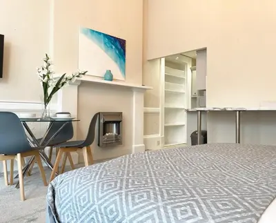 a bedroom with a bed and a table and a desk at The Buckingham Studio in Glasgow
