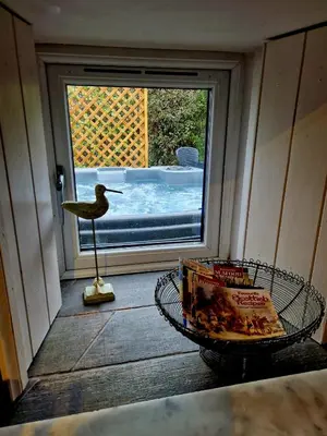 a room with a bird statue and a table and a window at Fyne Byre Cottage - Barn Conversion with Hot Tub in Cairndow