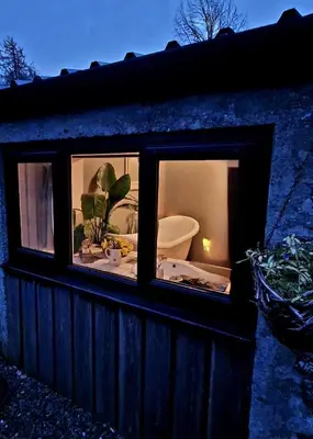 a window of a house with a toilet in it at Fyne Byre Cottage - Barn Conversion with Hot Tub in Cairndow