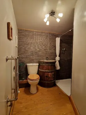 a bathroom with a toilet and a wooden barrel at Fyne Byre Cottage - Barn Conversion with Hot Tub in Cairndow