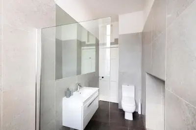 a white bathroom with a toilet and a sink at JOIVY Contemporary Flat in the New Town in Edinburgh