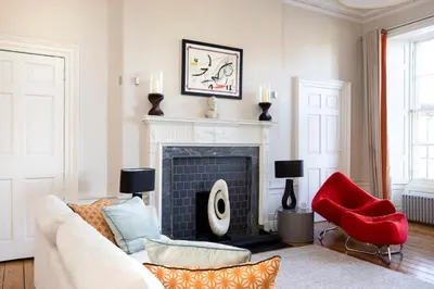 a living room with a couch and a fireplace at JOIVY Contemporary Flat in the New Town in Edinburgh