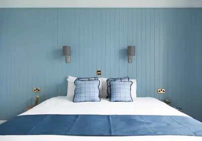 a blue bedroom with a large bed with blue walls at Coorie in Dunfermline