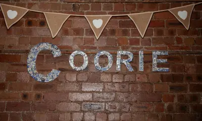 a sign on a brick wall with the word gopher at Coorie in Dunfermline