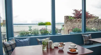 a table in a restaurant with a view of the water at Coorie in Dunfermline