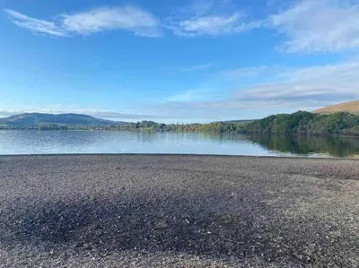 a view of a lake with mountains in the background at Charming stone Bothy at Loch Lomond in Luss