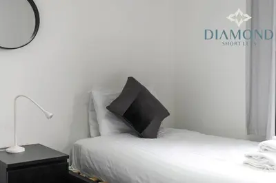 a bedroom with a bed with a black pillow on it at Cosy 2 Bed Apt West End Edinburgh FREE PARKING in Edinburgh
