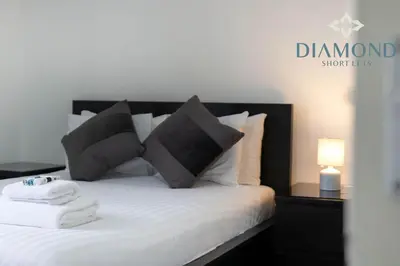 a bedroom with a bed with black and white pillows at Cosy 2 Bed Apt West End Edinburgh FREE PARKING in Edinburgh