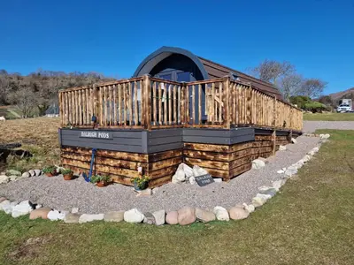 a building with a deck on top of a yard at Dalrigh Pod in Onich