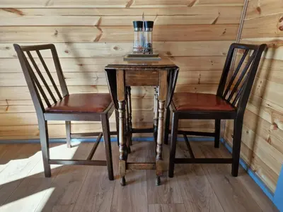a wooden table with two chairs and a lamp on it at Dalrigh Pod in Onich