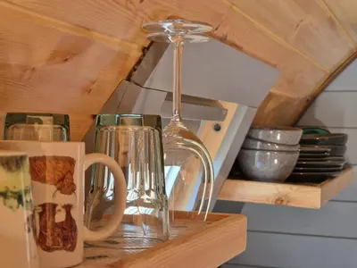 a kitchen counter with cups and a lamp on a shelf at Dalrigh Pod in Onich